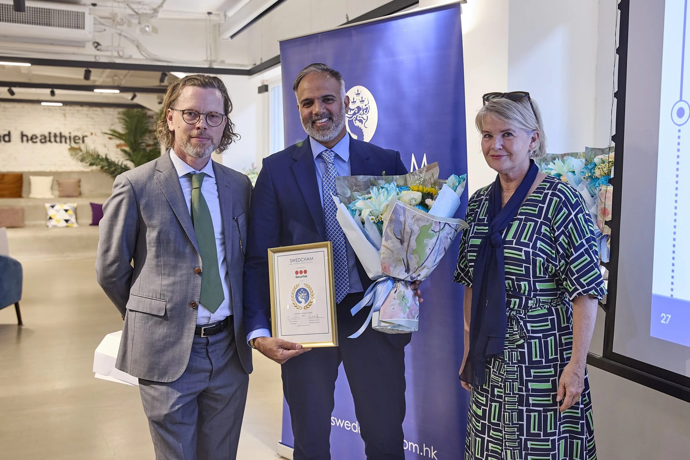 A member receiving flowers and a certificate at the Annual General Meeting